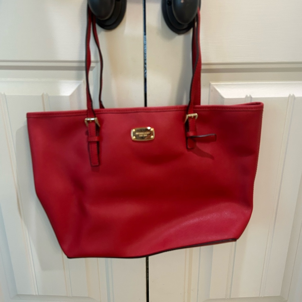 New, never used Michael Kors red bag with gold plating.